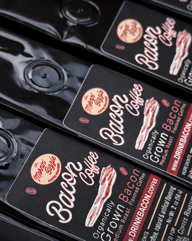 Macro view of black 2 oz Mornin' Sizzle Bacon Bitz coffee pouches